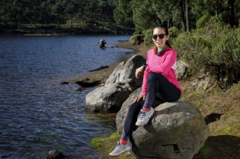 atleta-descansando-la-orilla-de-un-lago-sentada-sobre-una-piedra-despus-de-correr-en-el-bosque