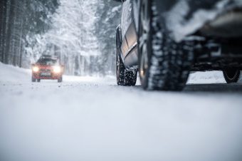 Coche circulando por carretera con nieve, riesgos laborales