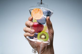 Person's,Hand,Holding,Saline,Bag,Filled,With,Various,Fruit,Slices